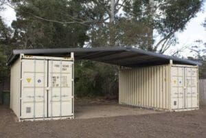 shipping container garage with roof in-between two containers.
